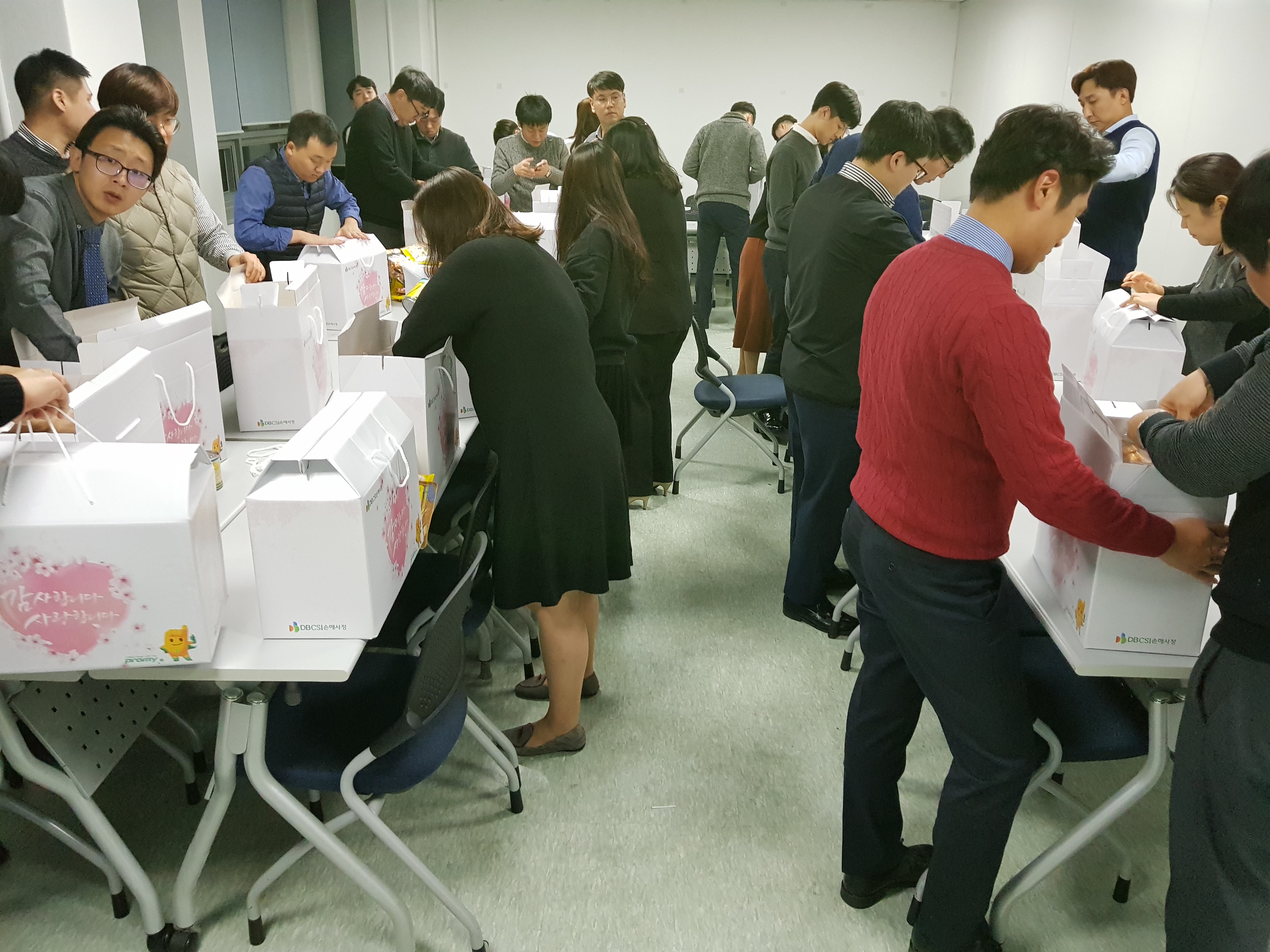 심사본부 임직원 일동이 상자를 만들고 있다.